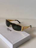 Celine sunglasses with gold metal frames, dark lenses, and tortoiseshell temple tips, resting on a white Celine box.